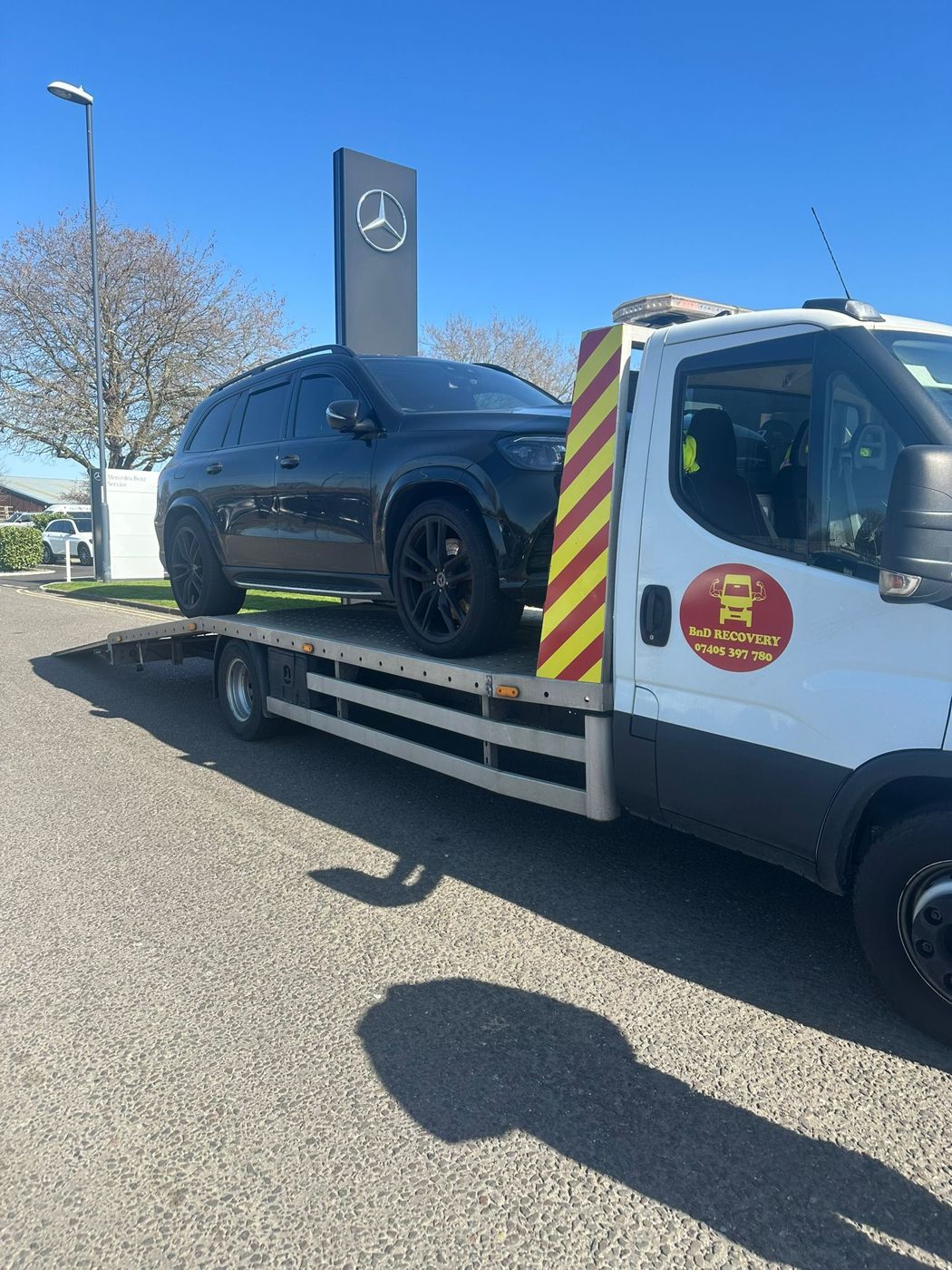 Black Mercedes SUV delivered to a Mercedes-Benz dealership on a BnD Recovery truck