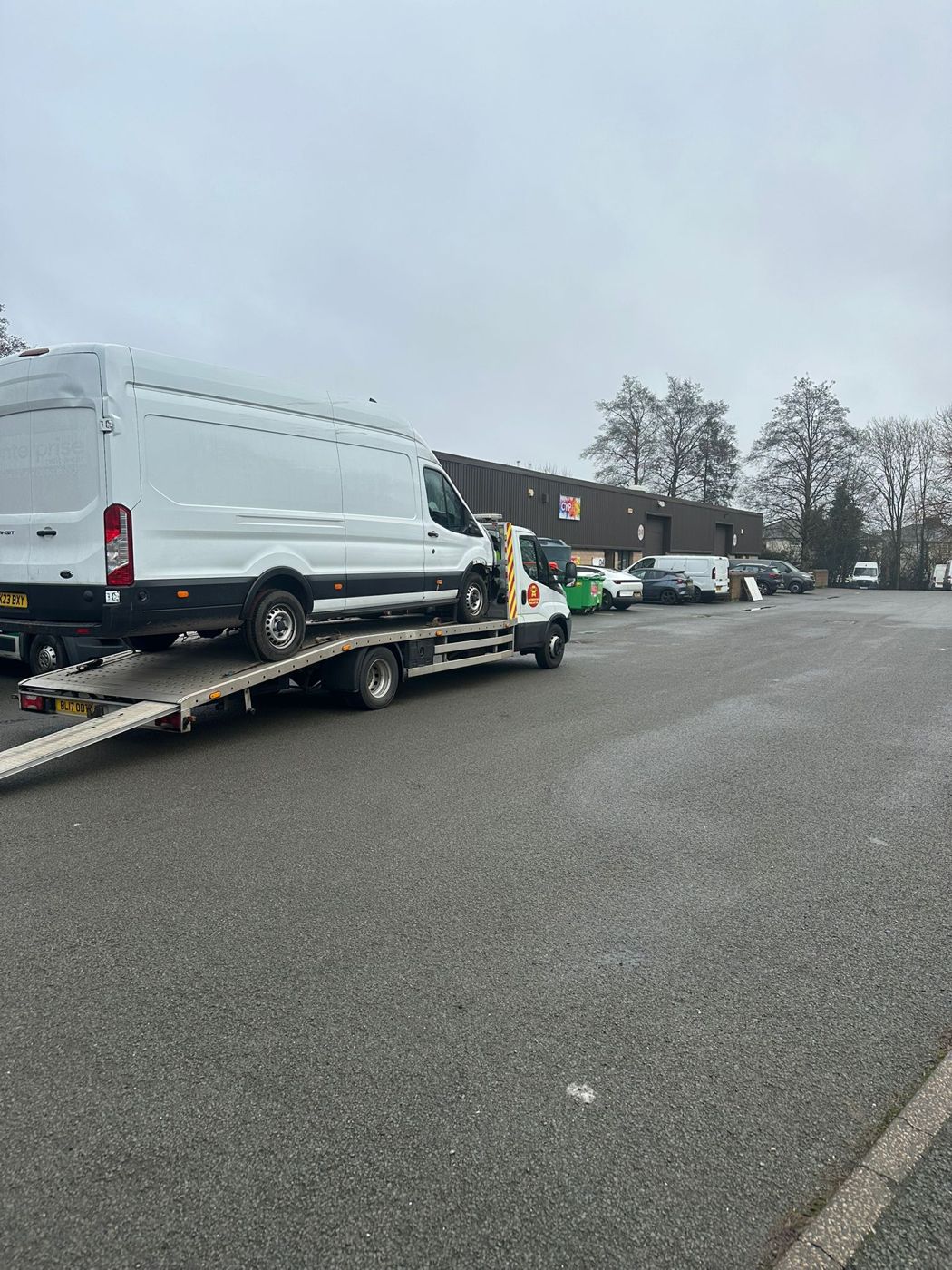 Large white panel van being transported on a BnD Recovery flatbed truck