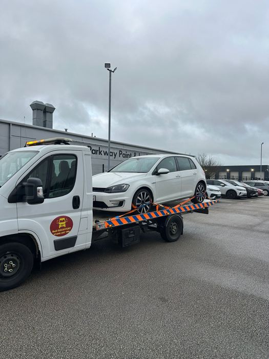Volkswagen Golf on a BnD Recovery flatbed outside a vehicle bodyshop