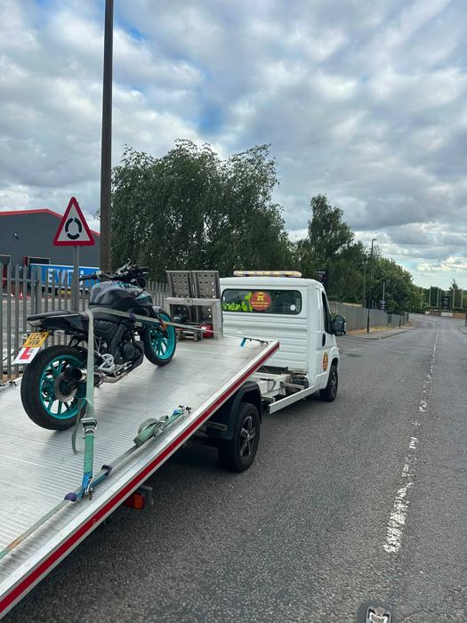 Motorbike strapped to a BnD Recovery flatbed truck ready for transport