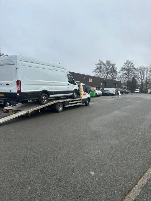 Large white panel van being transported on a BnD Recovery flatbed truck