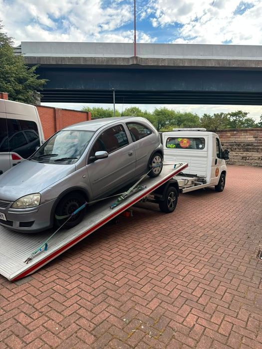 Car being winched onto a tilted BnD Recovery flatbed truck